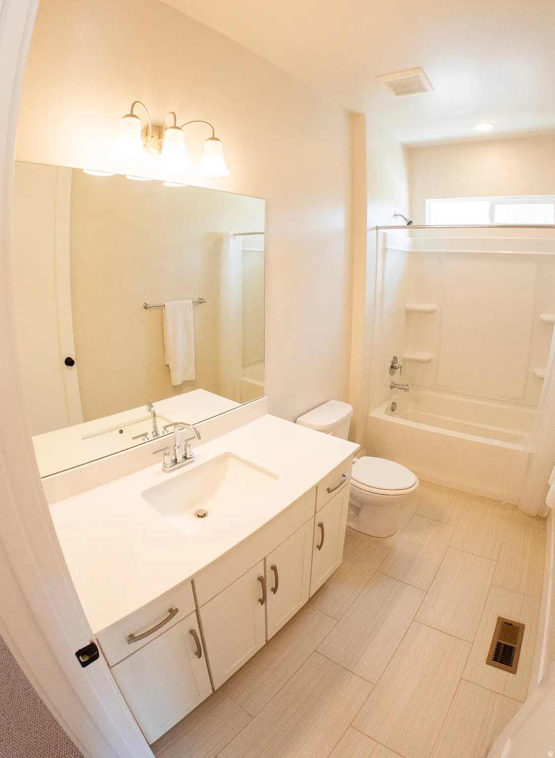 White vanity with integrated sink, brushed nickel faucet, and under-sink cabinetry