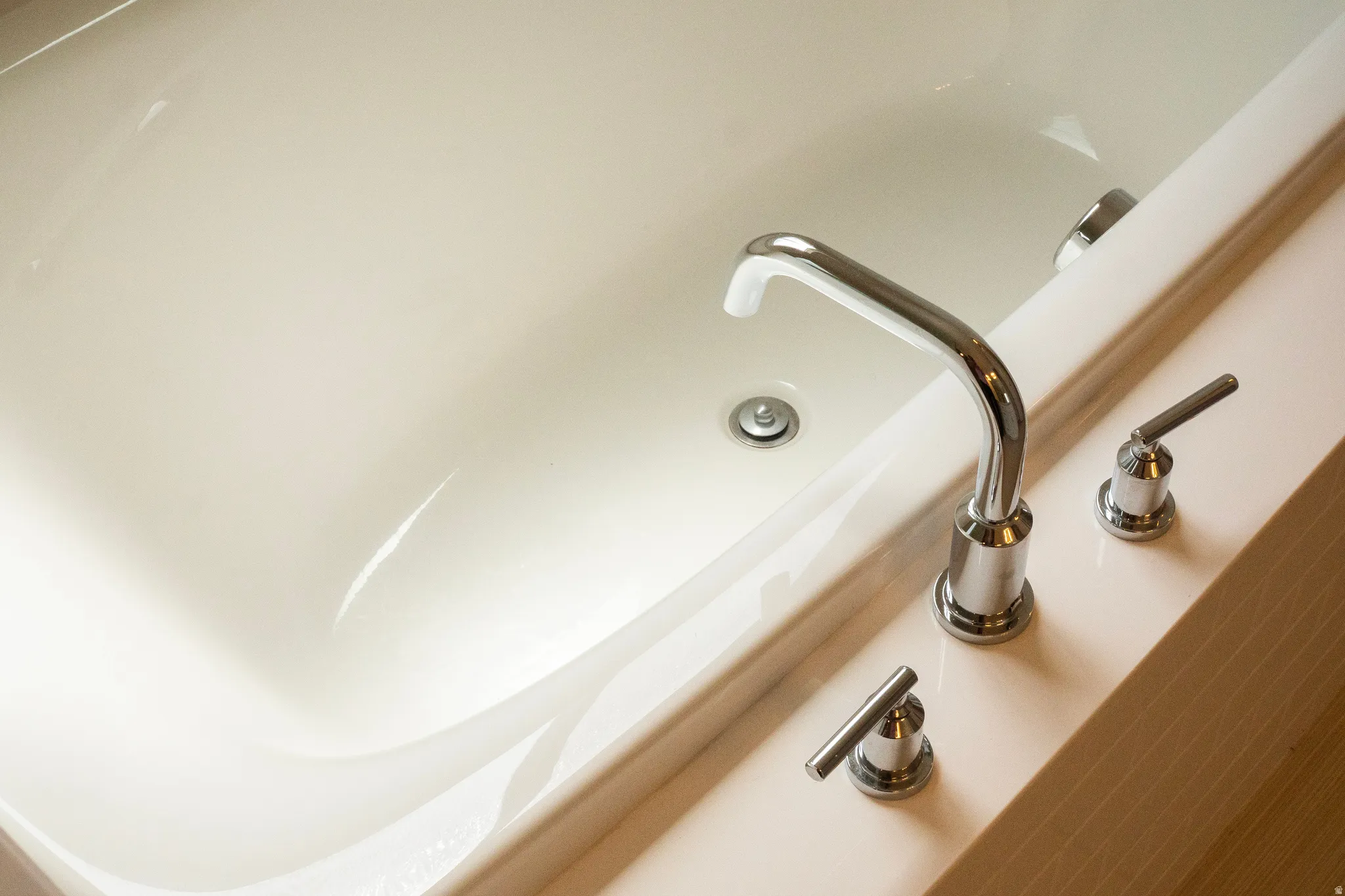 Soaking tub with polished chrome fixtures and an integrated overflow drain