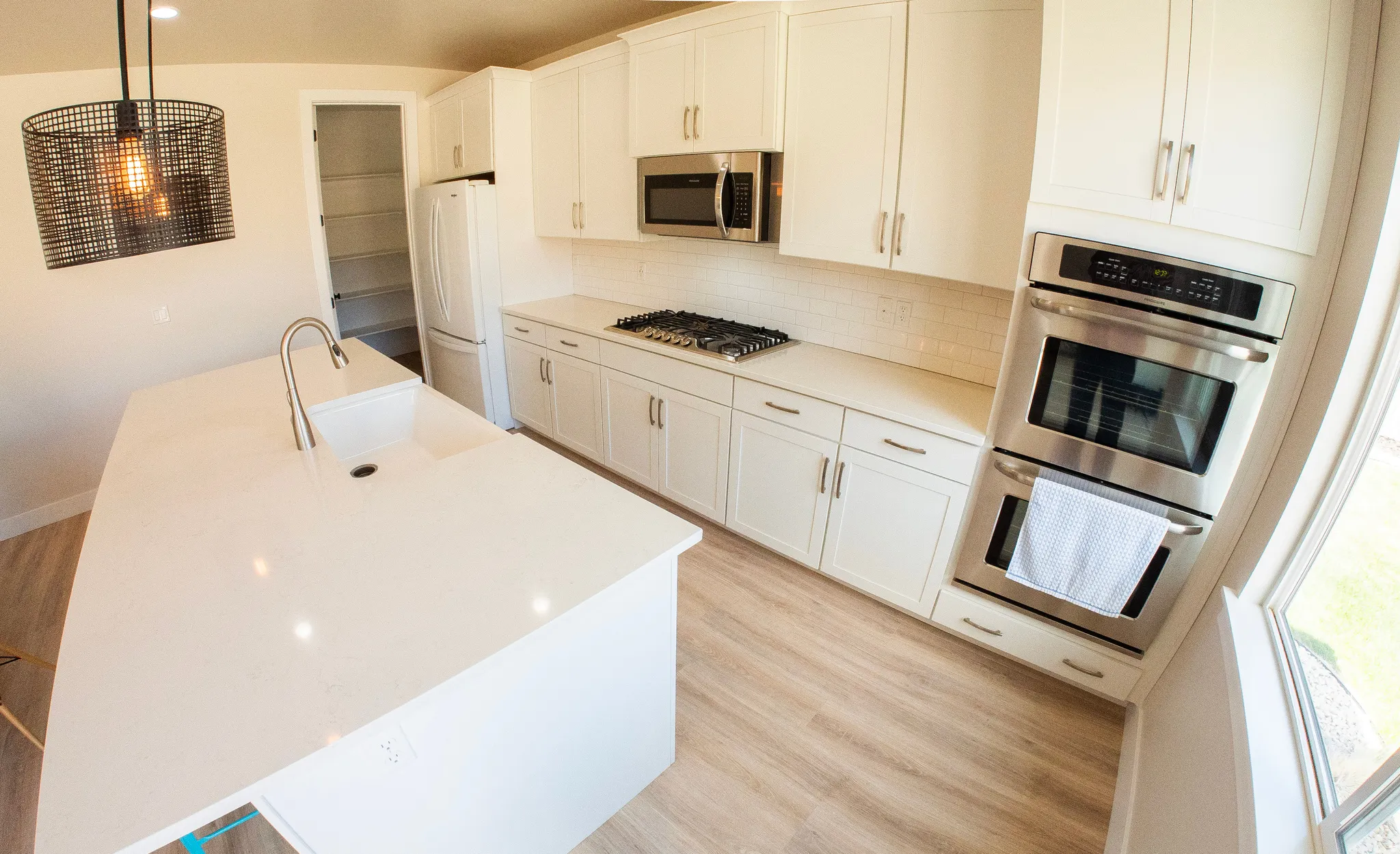 Modern kitchen featuring a large center island with an undermount sink and gooseneck faucet