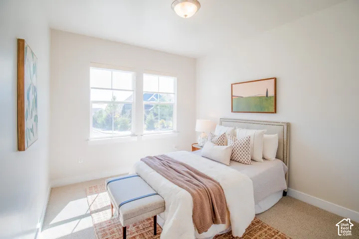 Bright room featuring two large windows, carpet flooring, and a ceiling-mounted light fixture