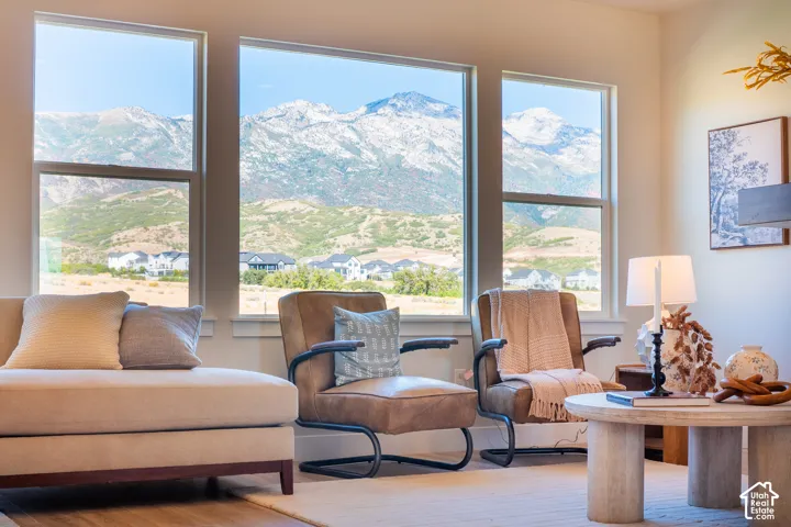 Expansive windows showcasing mountain scenery, light-toned walls, and wood-finish flooring
