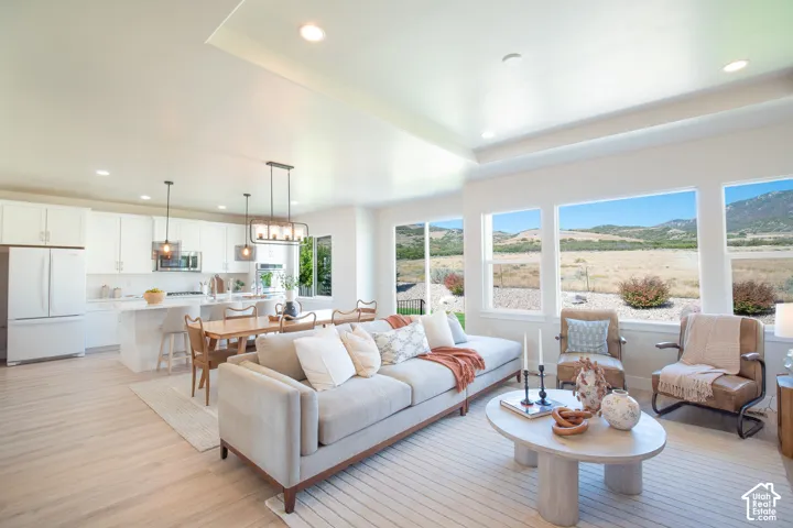 Open-concept living area with tray ceiling and recessed lighting