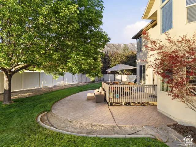 Expansive exterior featuring a wood deck, stamped concrete patio, and a manicured lawn