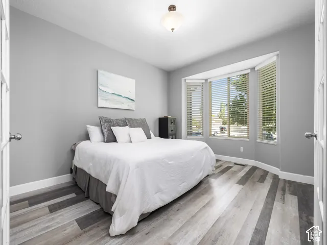 Room featuring a bay window, wood-finish flooring, and white baseboards