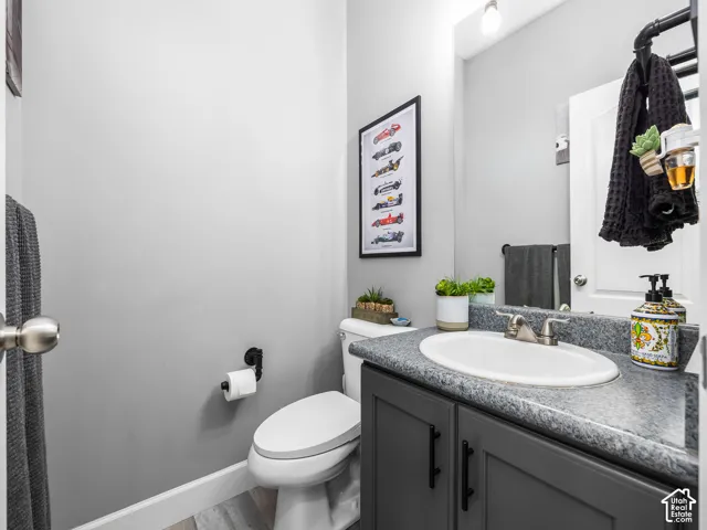 Neutral gray walls frame this powder room featuring a gray vanity with a built-in sink, brushed nickel faucet, and a wall-mounted mirror