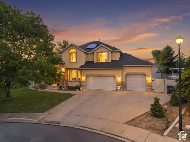 Two-story stucco exterior with stone accents, two-car garage, and arched window details