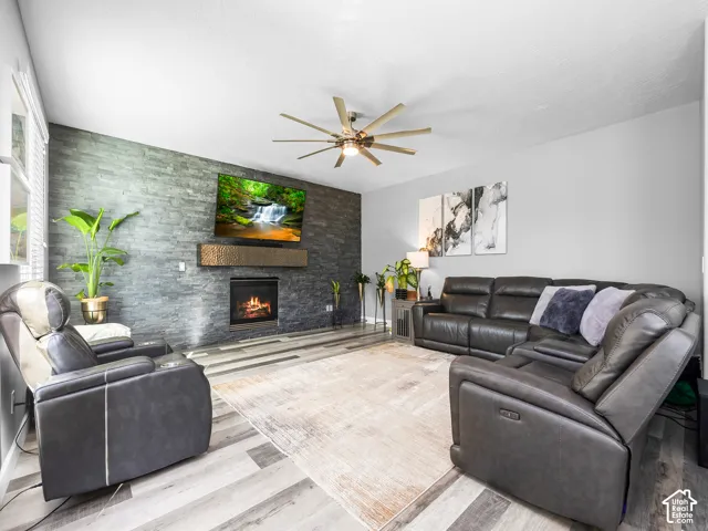 Living area featuring a floor-to-ceiling stacked stone accent wall with a built-in fireplace