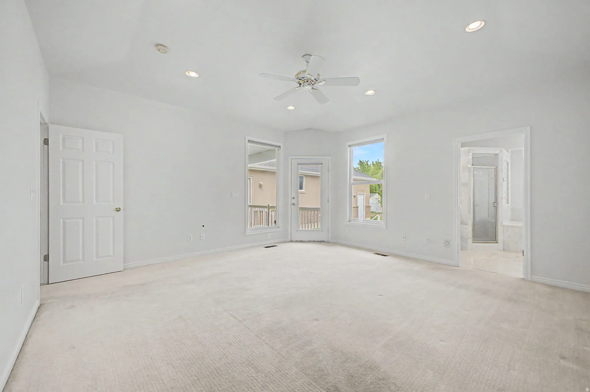Spacious room featuring vaulted ceilings, recessed lighting, a ceiling fan, and light-toned carpeting