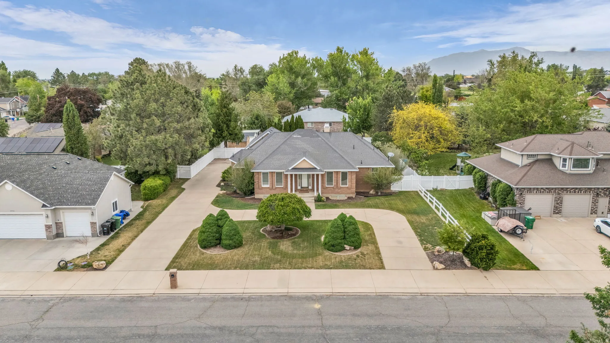 Traditional brick residence with a columned front entry, a circular driveway, and a well-manicured front lawn