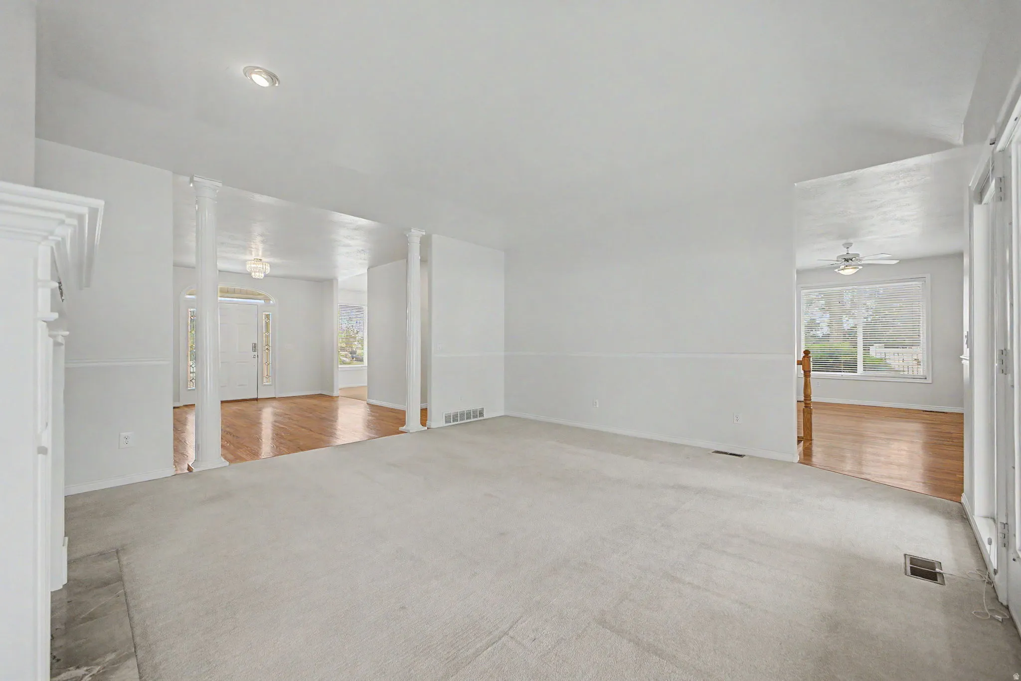 Spacious carpeted room featuring white walls and recessed lighting