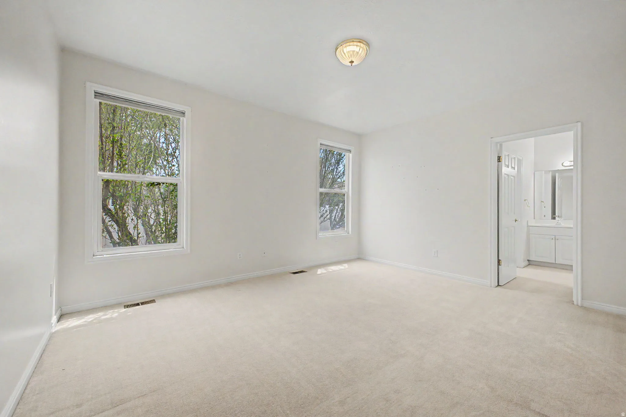 Spacious room featuring neutral carpeting and white walls