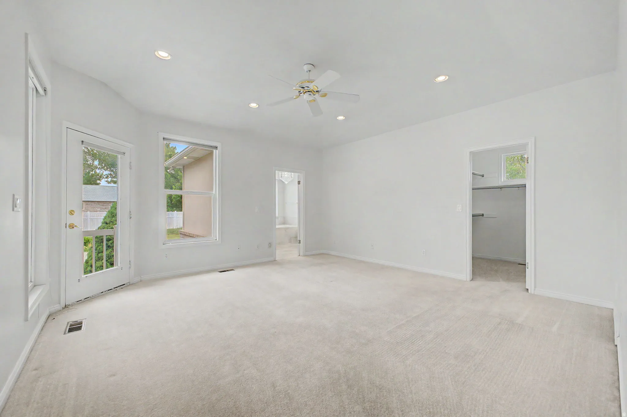 Spacious room with plush carpet flooring, recessed lighting, and a ceiling fan