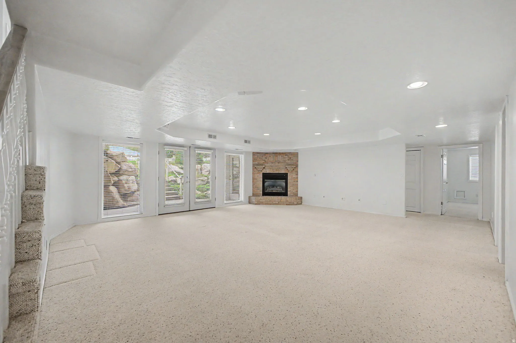 Spacious interior with neutral carpeting and recessed lighting