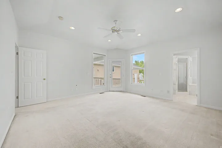 Spacious room featuring vaulted ceilings, recessed lighting, a ceiling fan, and light-toned carpeting