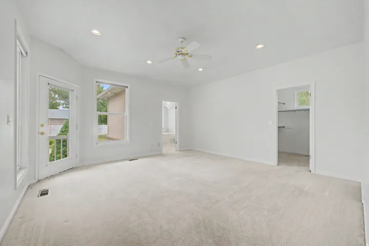 Spacious room with plush carpet flooring, recessed lighting, and a ceiling fan