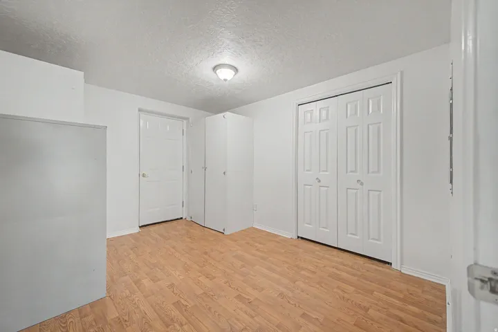 Room featuring wood-finish flooring, a bi-fold closet, and recessed lighting