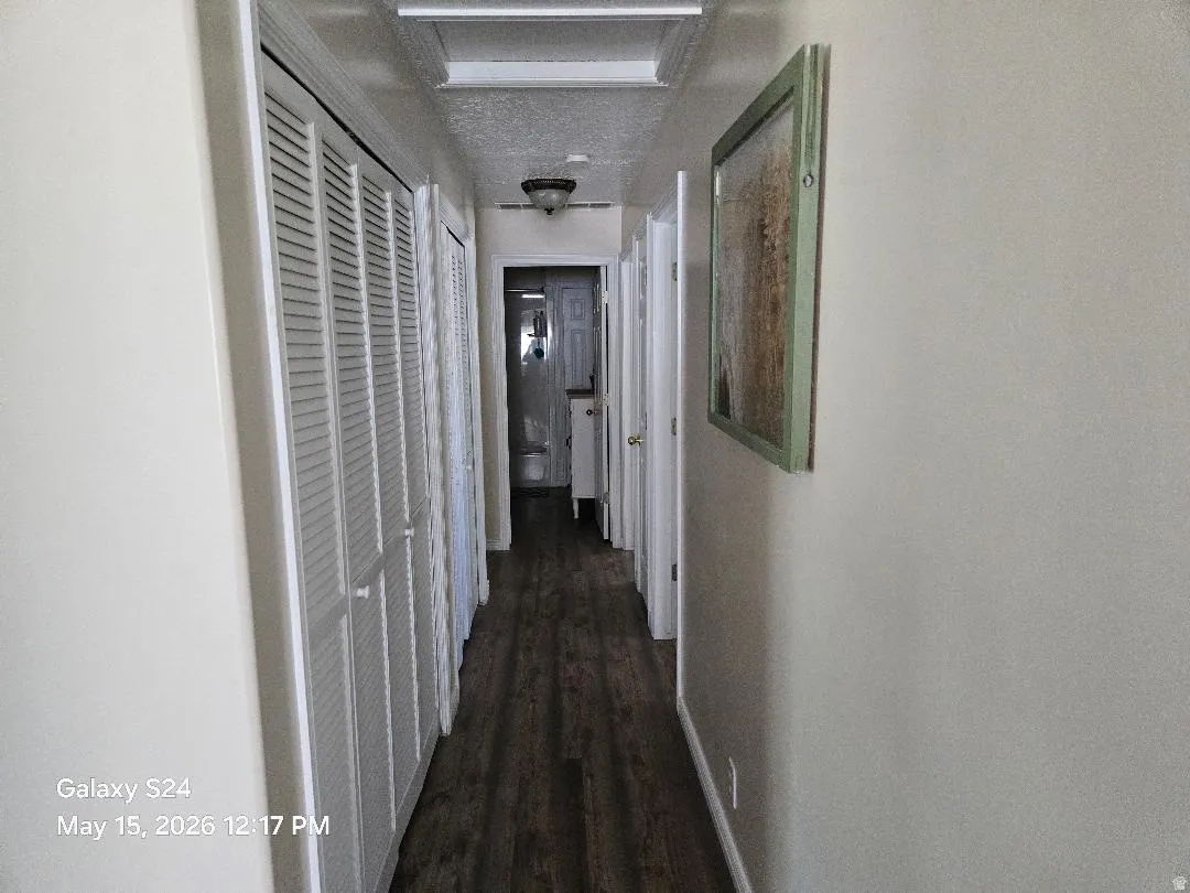 Hallway featuring wood-finish flooring, louvered bi-fold closet doors for linens/storage and laundry and recessed ceiling lighting