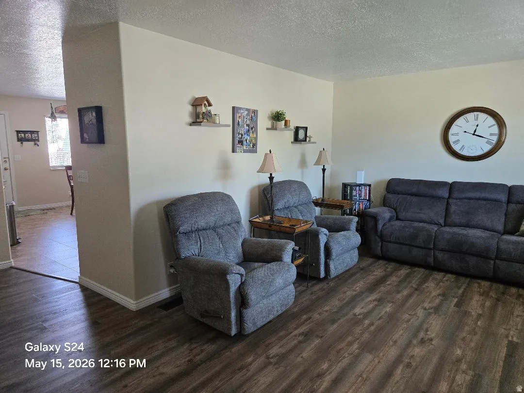 Spacious living area featuring wood-finish flooring, neutral wall tones, and recessed lighting