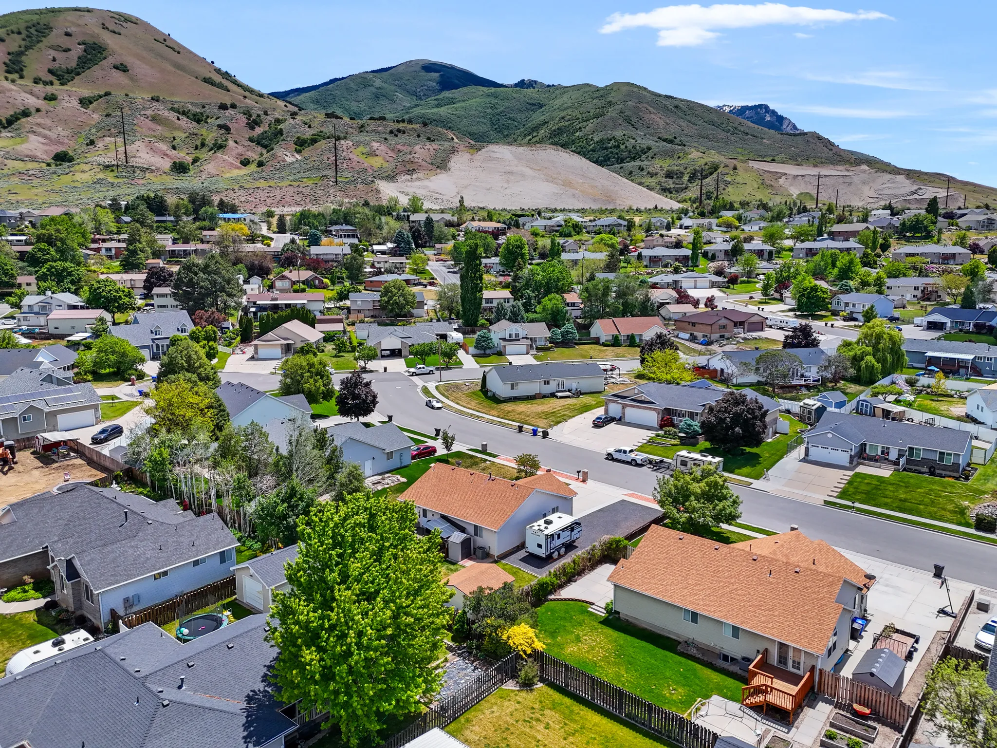 Residential neighborhood with established homes and mature landscaping, set against a backdrop of natural mountain terrain