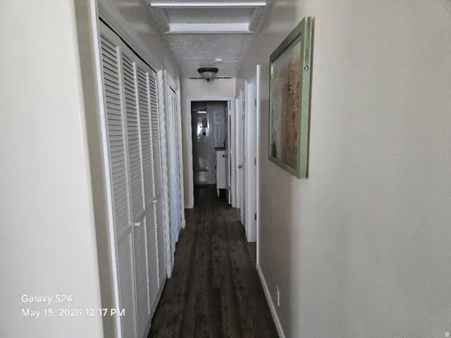 Hallway featuring wood-finish flooring, louvered bi-fold closet doors for linens/storage and laundry and recessed ceiling lighting