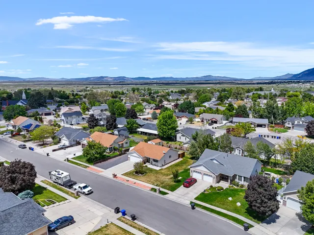 Suburban neighborhood featuring a variety of residential properties with mature landscaping and mountain scenery in the distance