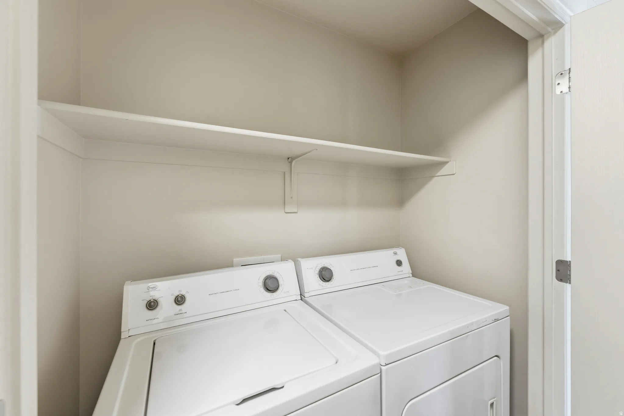 Dedicated laundry area featuring a white built-in shelf