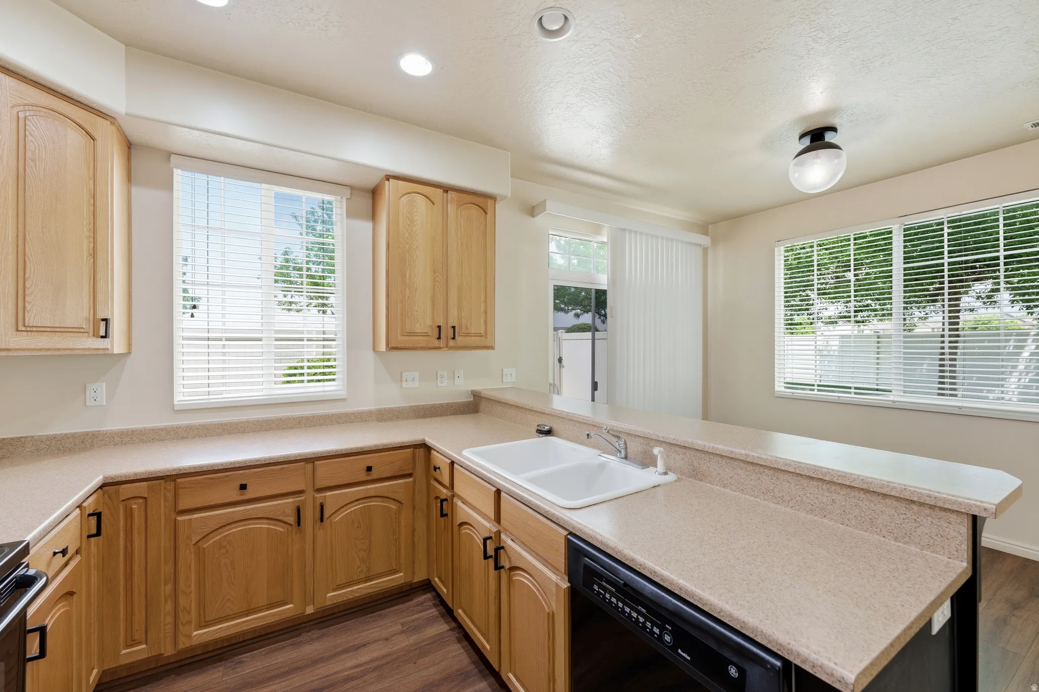 Kitchen featuring wood-finish cabinetry, a double basin sink, and ample countertop space