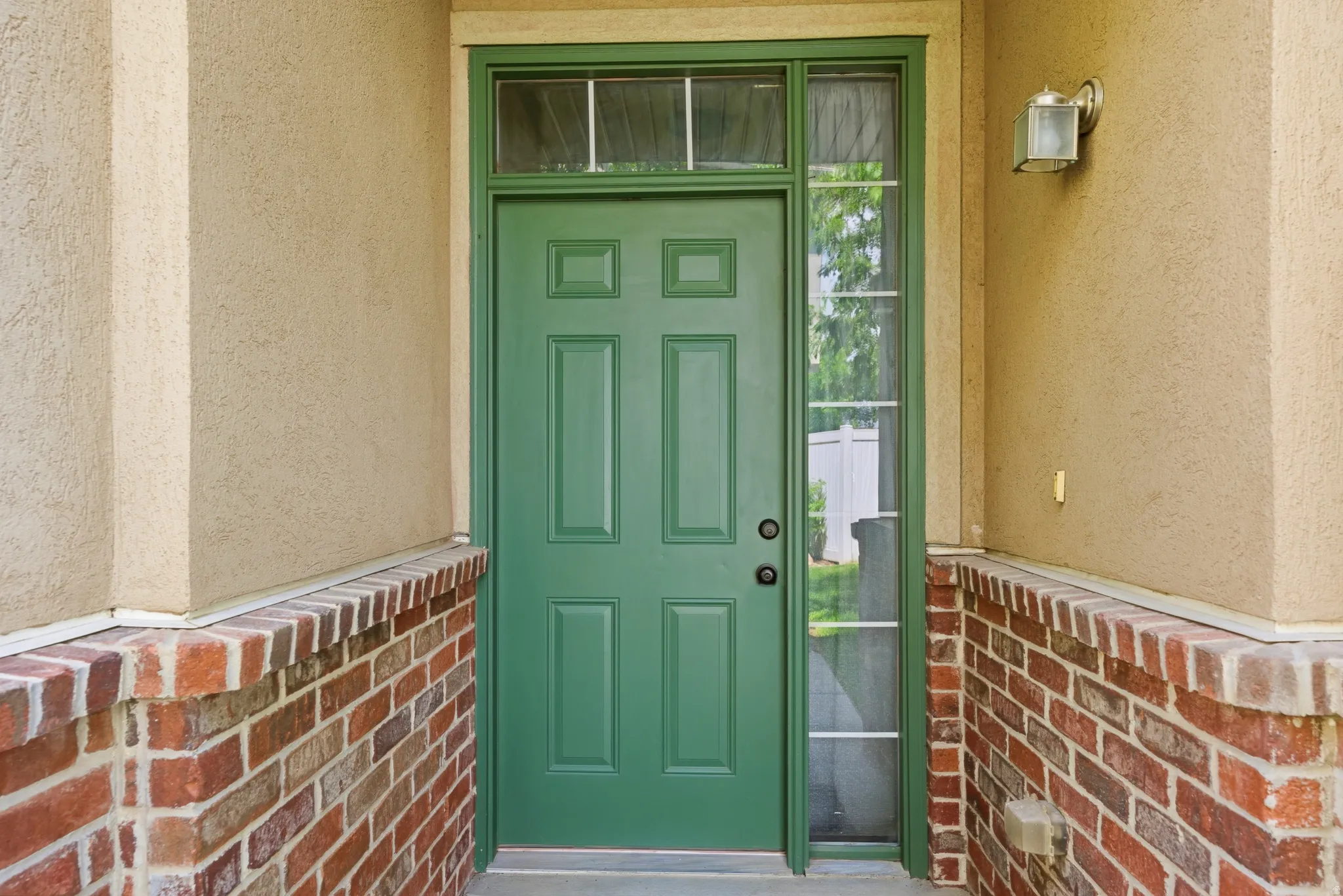 Entryway featuring a six-panel door with sidelight and transom windows