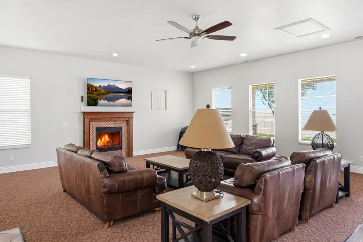 Club house Living space featuring a tiled fireplace with wood surround, recessed lighting, and multiple windows