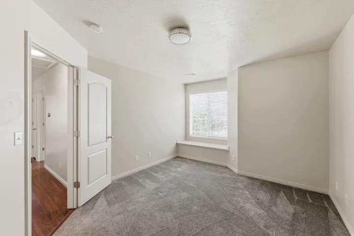 2 guest bedRoom featuring neutral wall tones and a window with blinds