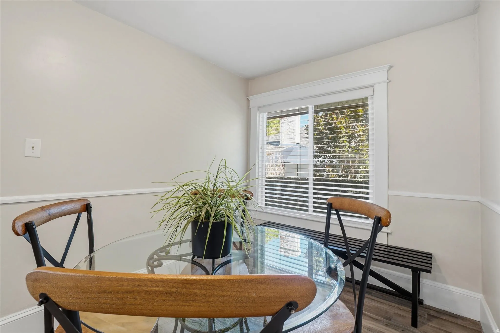 Bright interior space with wood-finish flooring, white baseboards, and chair rail molding
