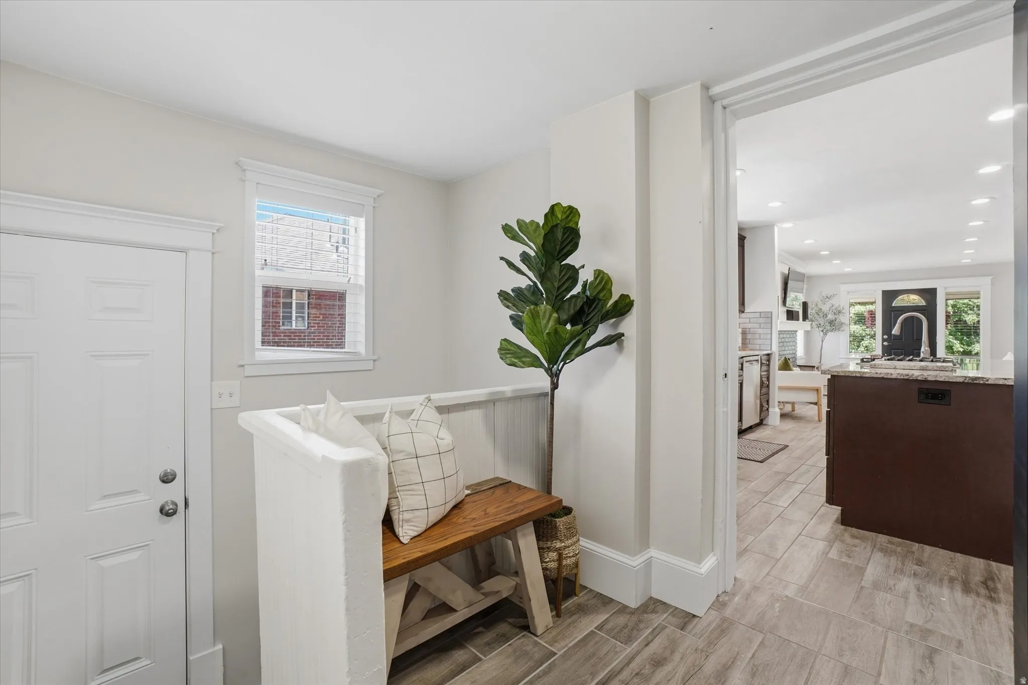 Entryway featuring wood-finish tile flooring, a white paneled door, and a single window with white trim
