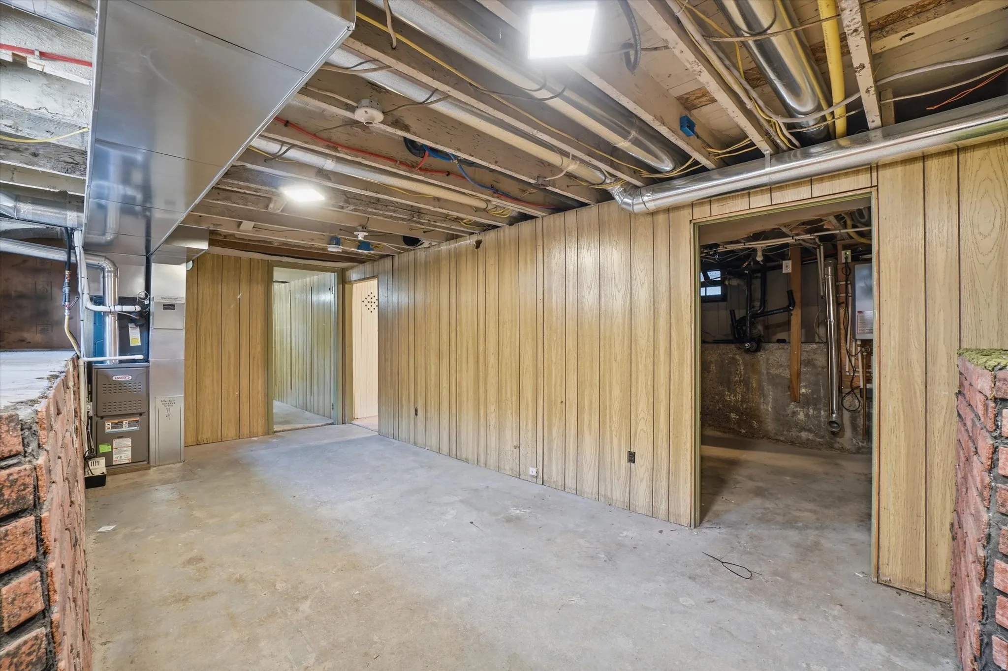 Unfinished basement with concrete flooring and exposed ceiling joists
