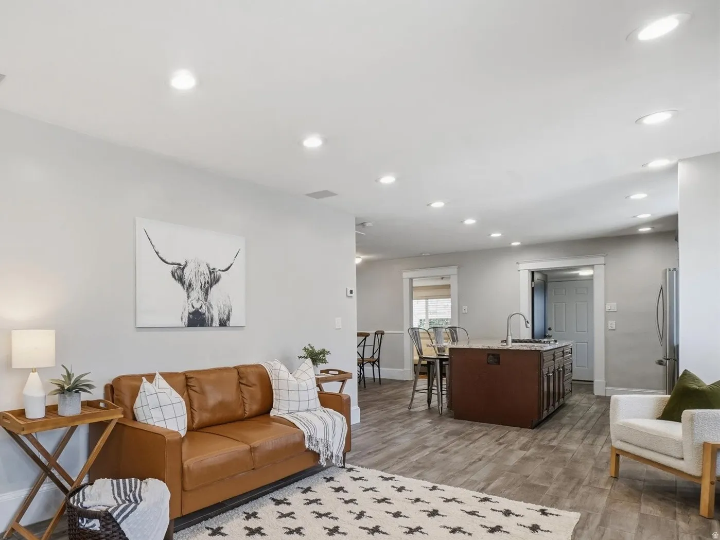 Open-concept living area featuring wood-finish flooring, recessed lighting, and a built-in media niche