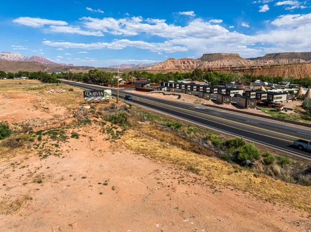 Expansive undeveloped land featuring a prominent commercial sign and direct road frontage