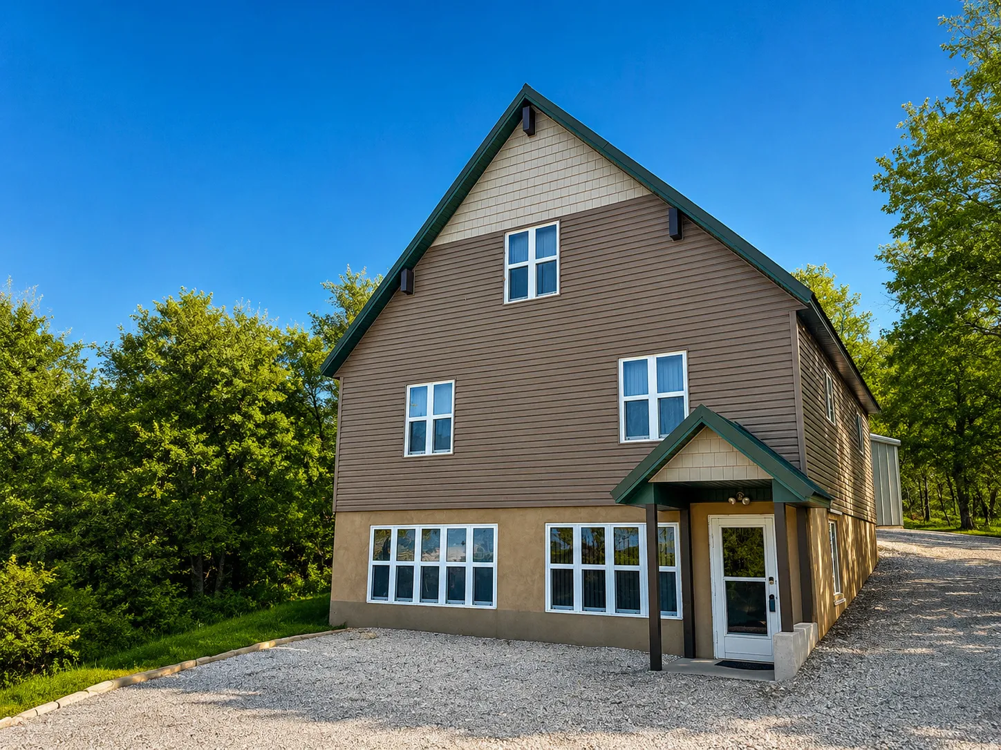 Modern-style exterior featuring a gravel driveway, multiple windows, a covered entryway, and a combination of horizontal siding and shake shingles