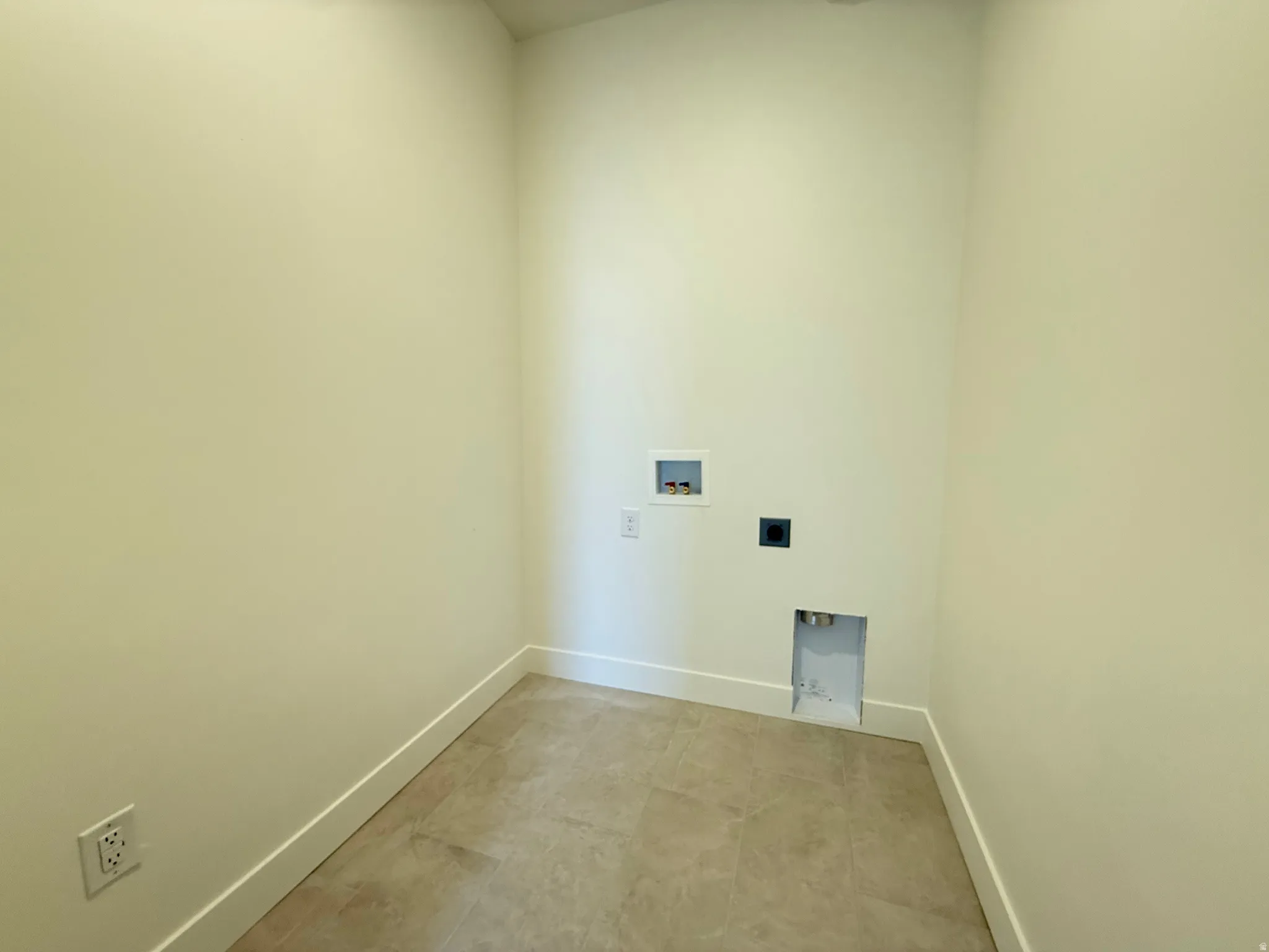 Laundry utility room featuring tile flooring, neutral wall tones, and white baseboards