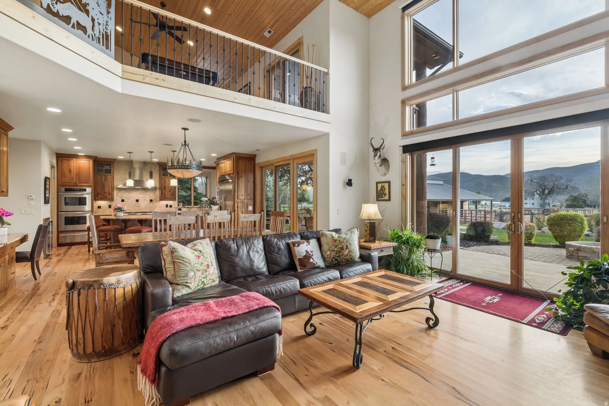 Living area featuring a mountain view, light wood-style flooring, a high ceiling, recessed lighting, and french doors