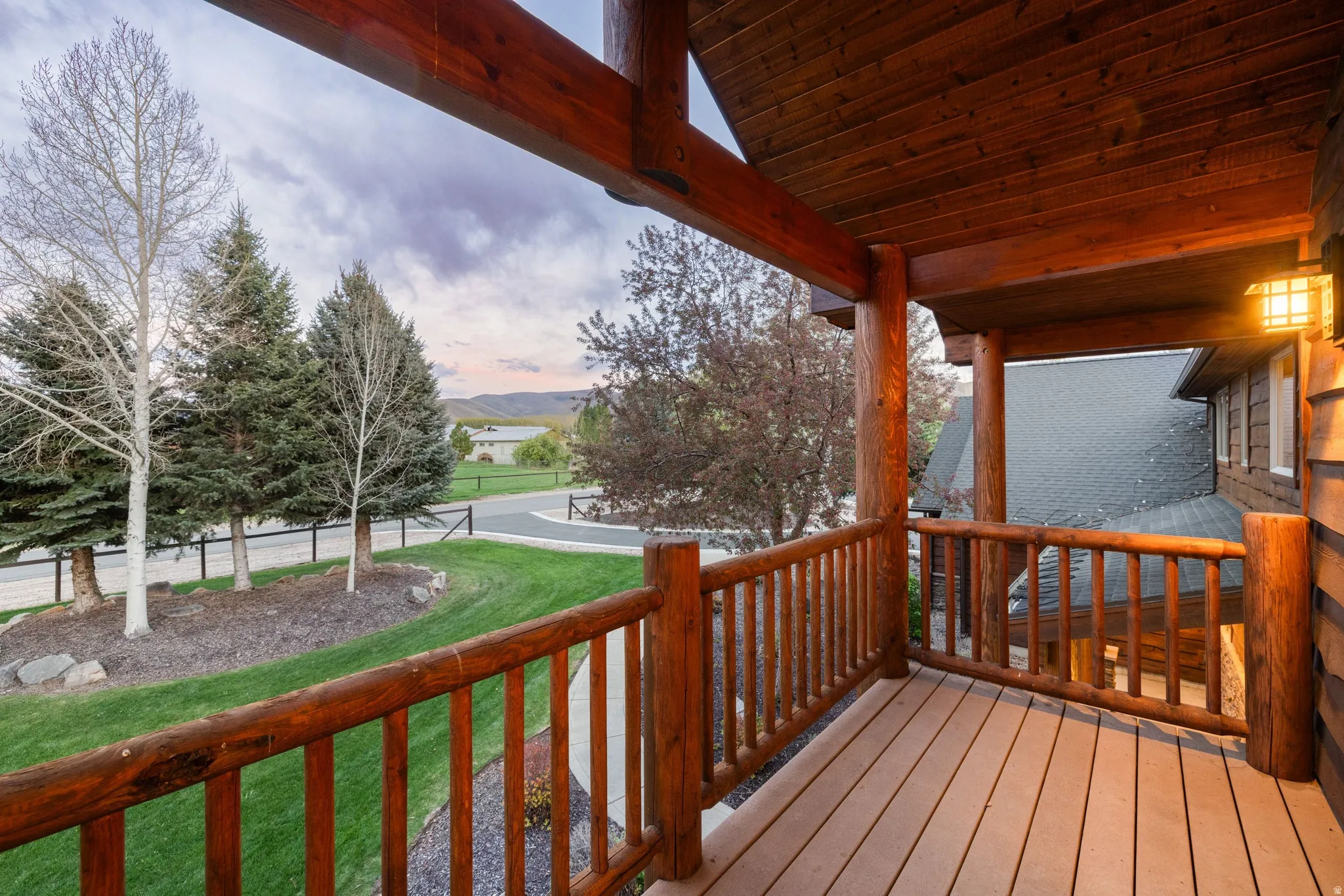 Deck at dusk featuring a yard and a balcony