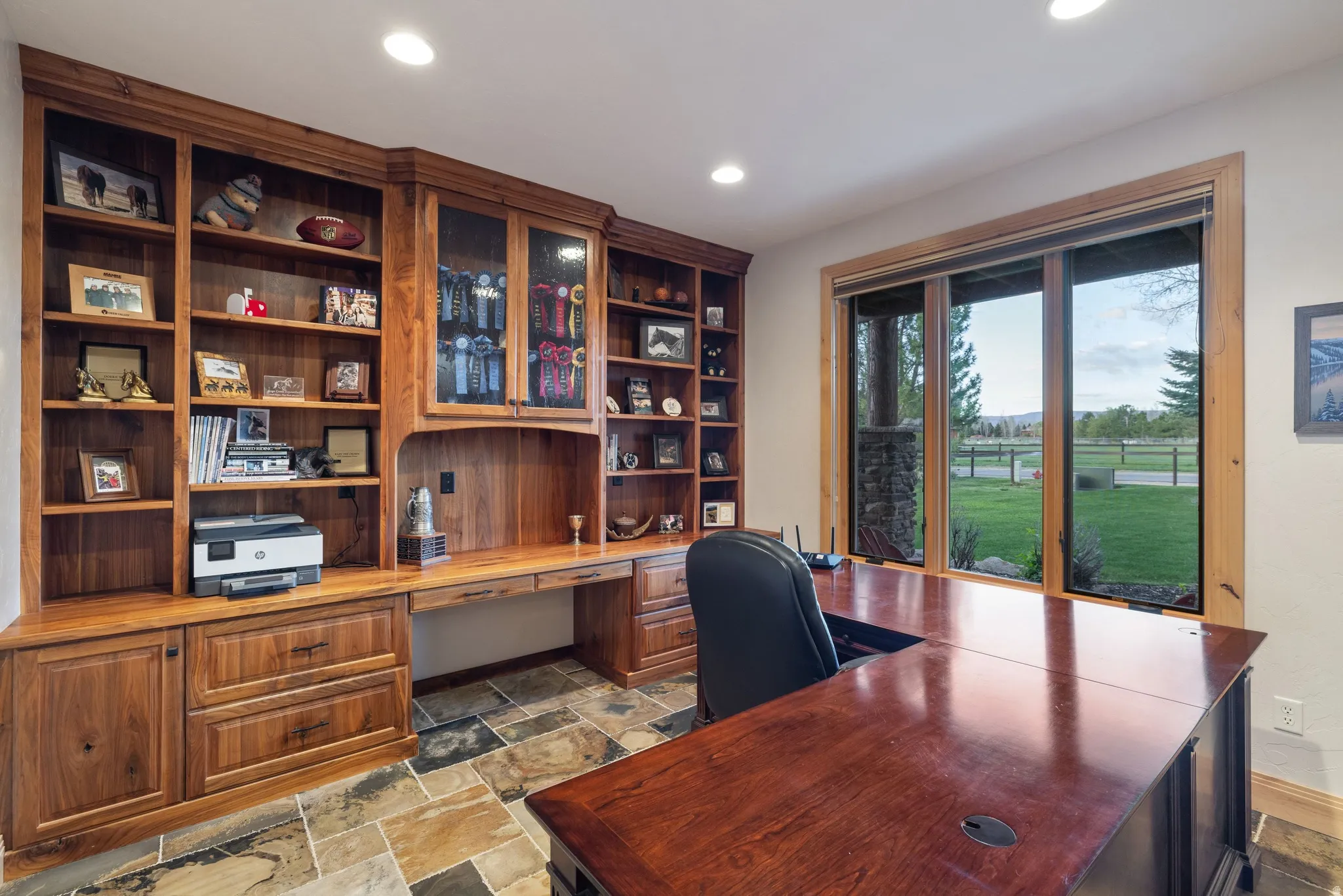 Office space with built in desk, stone tile floors, and recessed lighting