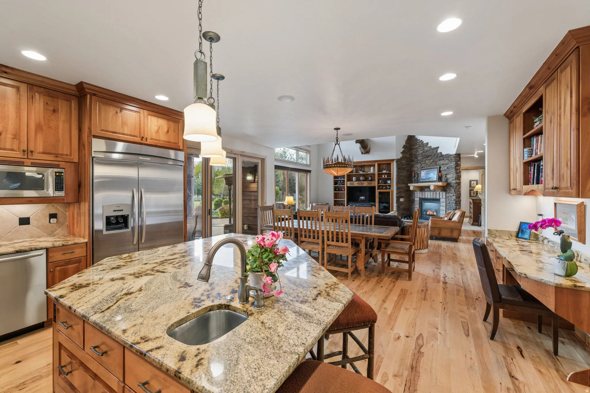 Kitchen featuring wood finish cabinetry, built in appliances, and light stone counters