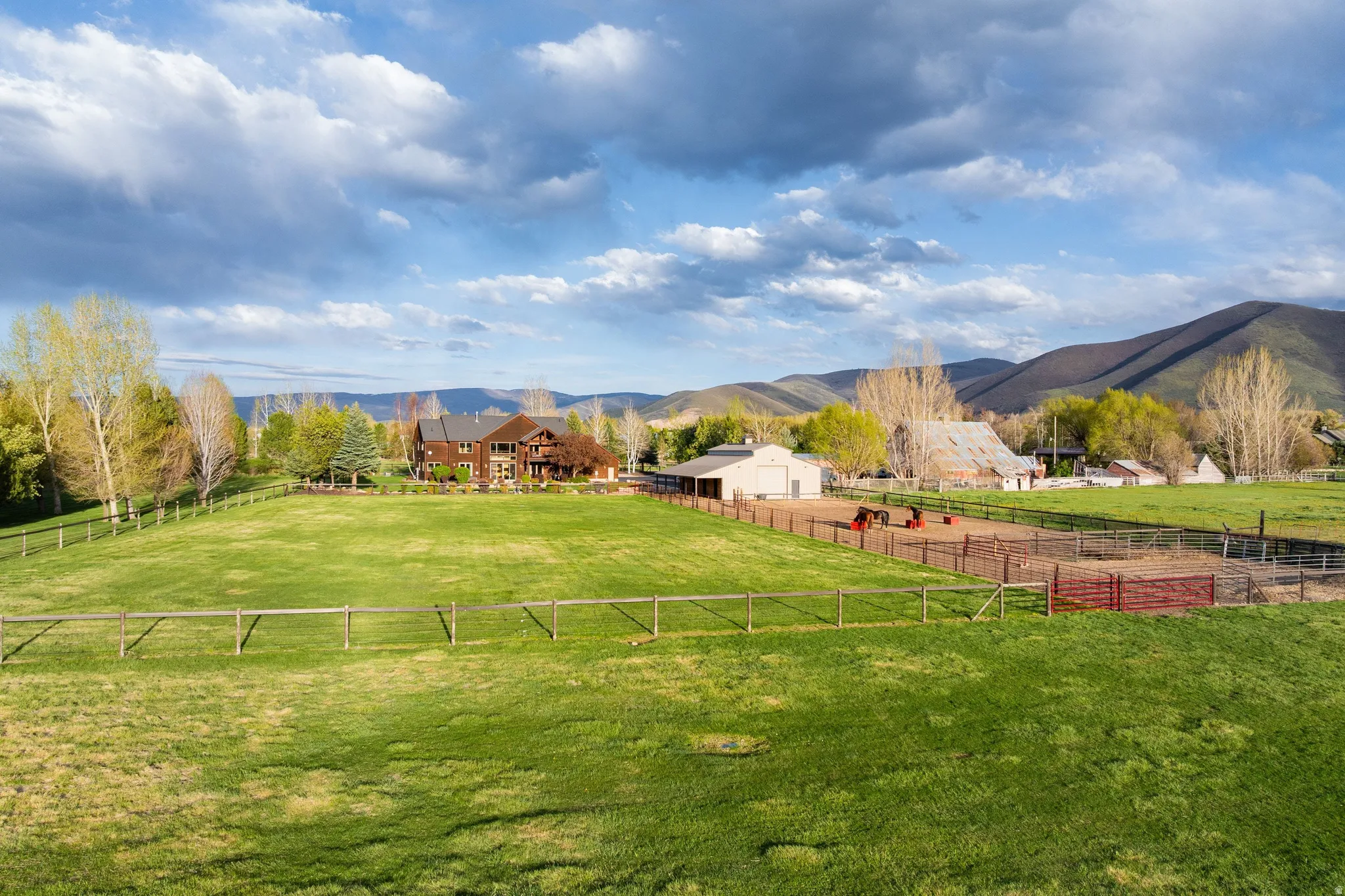 View of yard with an outdoor structure, a mountain view, a view of countryside, and an outdoor riding arena