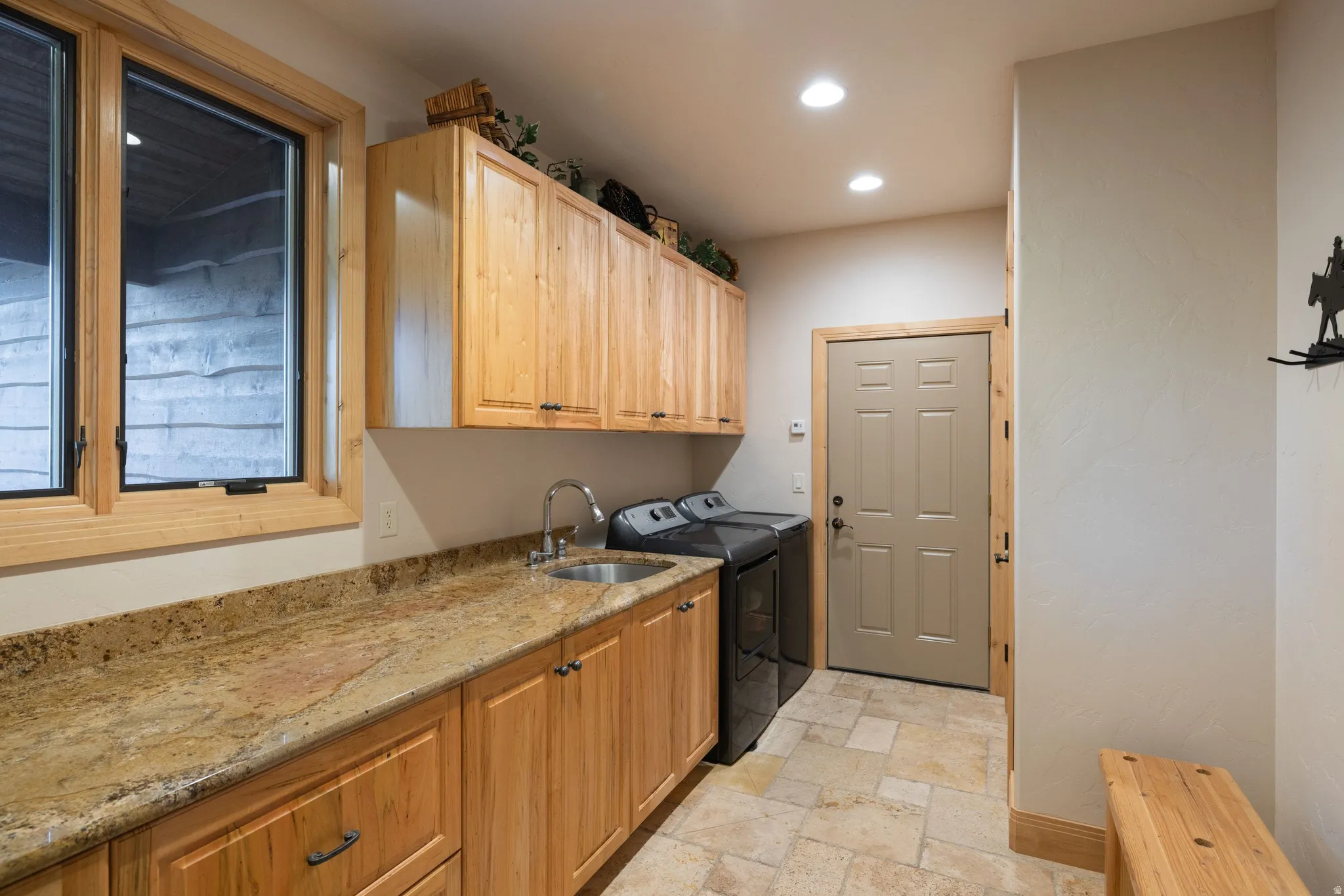 Laundry room with stone tile floors, cabinet space, separate washer and dryer, and recessed lighting