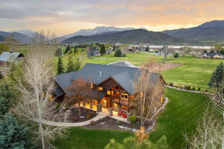 Rear view of house with a lawn, a mountain view, and stone siding