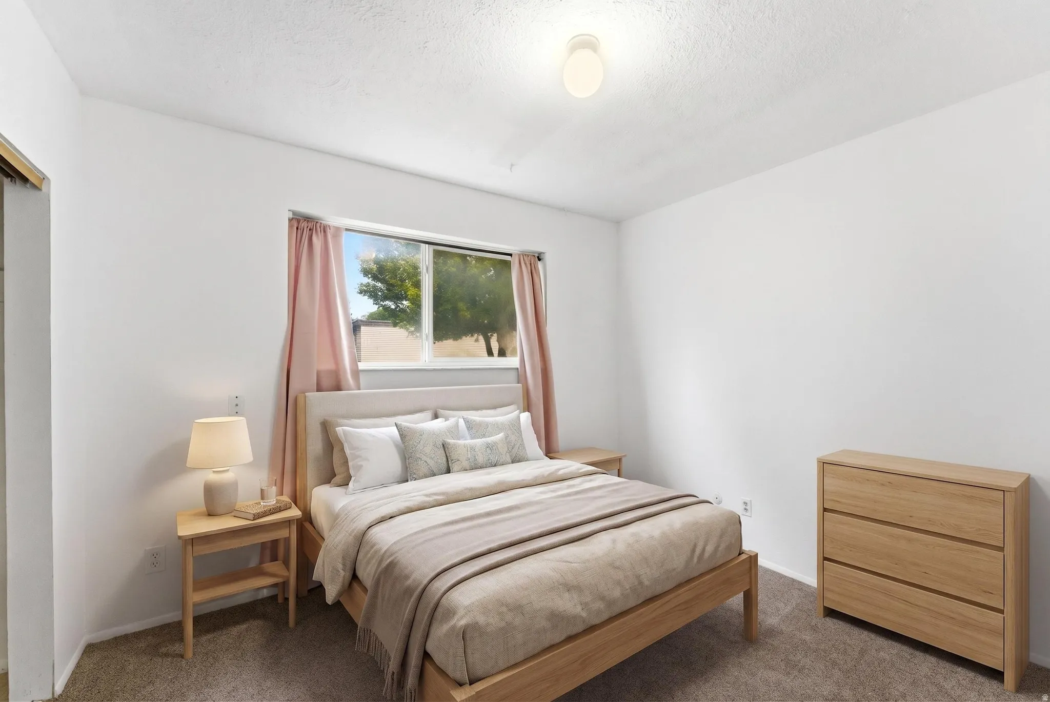 Bright bedroom with light-toned walls and plush carpeting