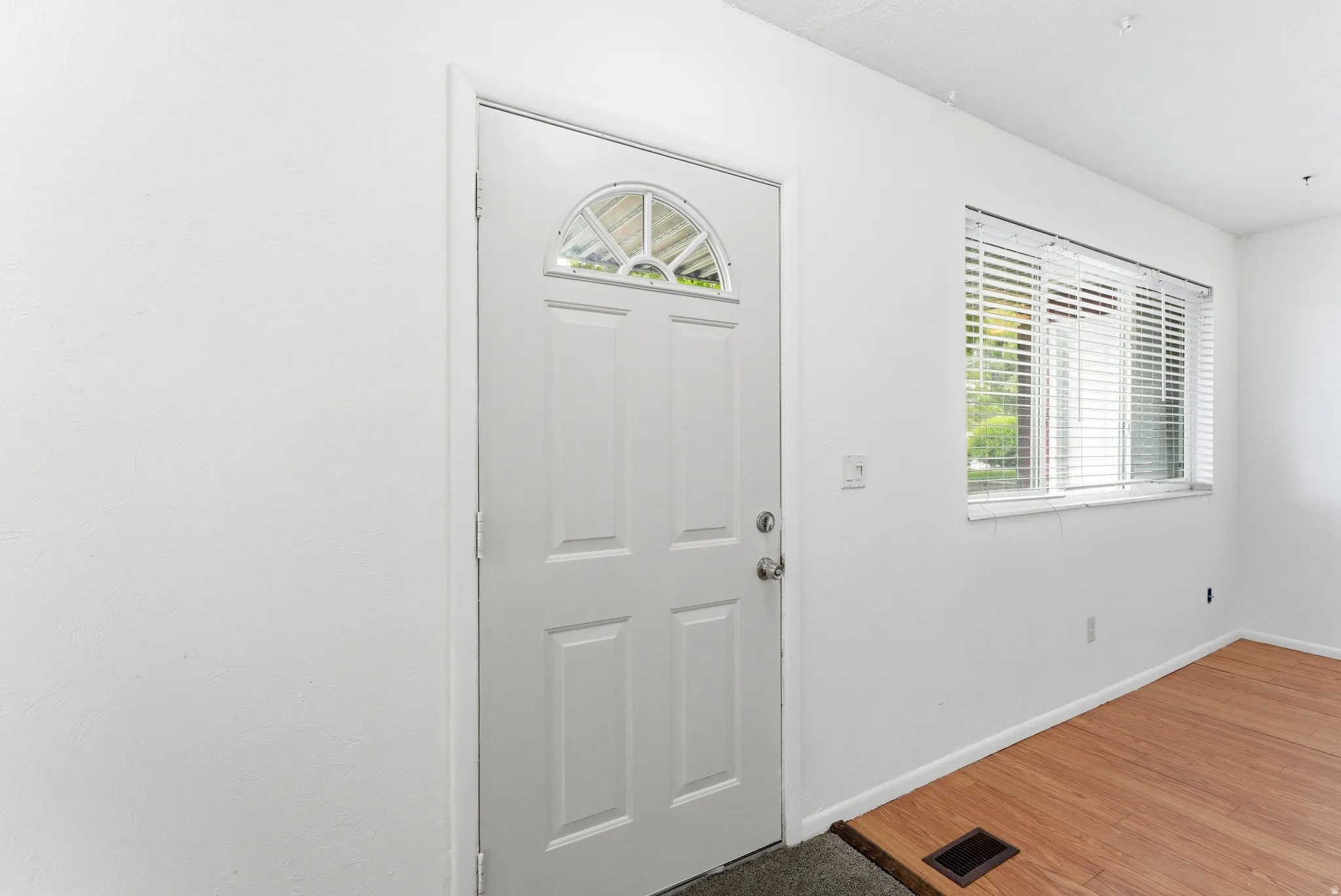 Entry door featuring a decorative arch window