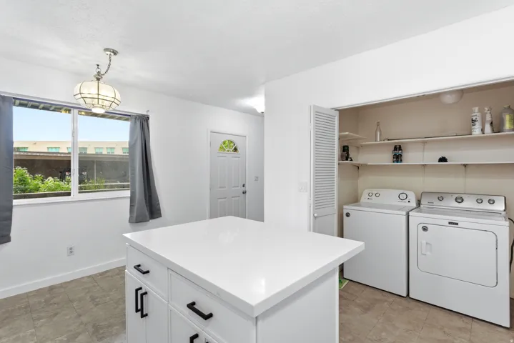 Central island with a white countertop and black hardware