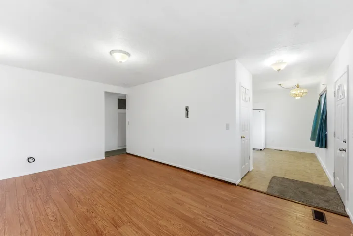 Spacious interior featuring wood-finish flooring, white walls, and a ceiling-mounted light fixture