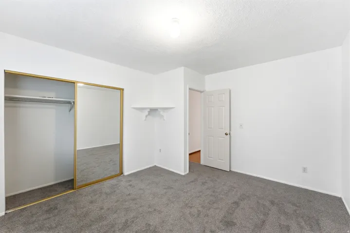 Bedroom featuring gray carpeting, white walls, and a white ceiling with a flush-mount light fixture