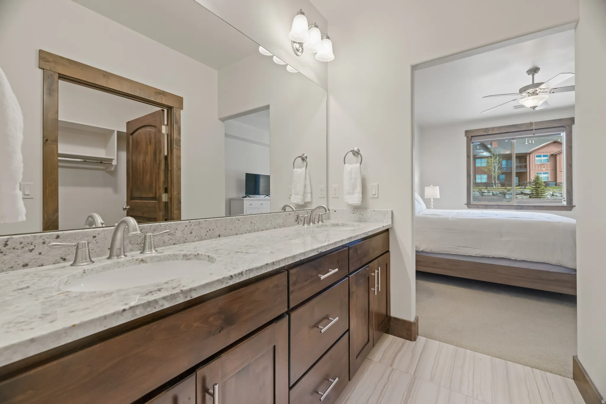 Dual vanity with integrated sinks and a stone-finish countertop, complemented by dark wood cabinetry